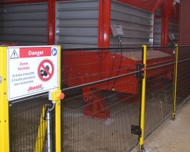 SECURITE : Système de sécurité aux normes industrielles avec grilles de protection et arrêts d’urgence sur l’installation.
